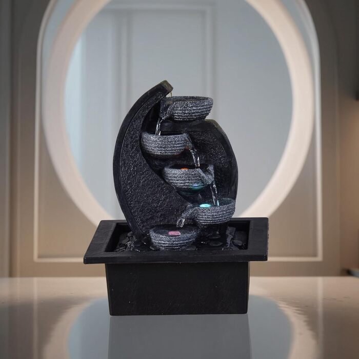 Джерело води Zen'Light Zimmerbrunnen V2 з 4 рівнями, імітація натурального каменю та кольоровим LED-підсвічуванням. Сучасна декор для столу, ідеально для медитації та релаксації. Висота 26 см. Унікальний дизайн.